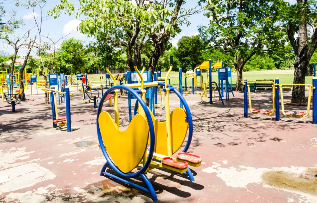 Outdoor gym equipment installed in a community park, designed for various exercises.